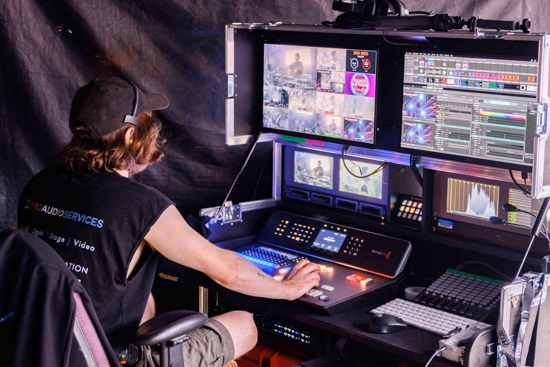 Man sat at touring video production station editing multiple camera feeds