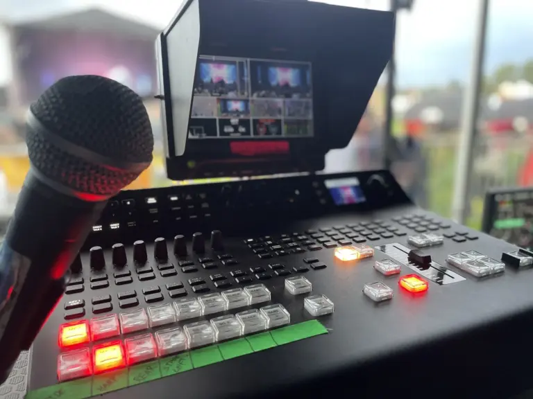 Video production desk with a vision mixer, a microphone and a camera monitor