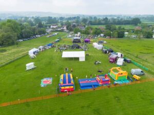 Aerial view of a field with a stage, stalls and childrens area.
