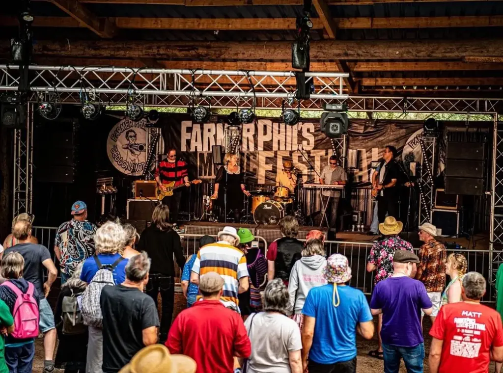 Band playing on stage under the Farmer Phil's Festival banner with the crowd watching