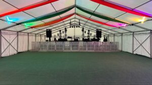 Marquee with stage at one end with speakers at the front and lights at the back
