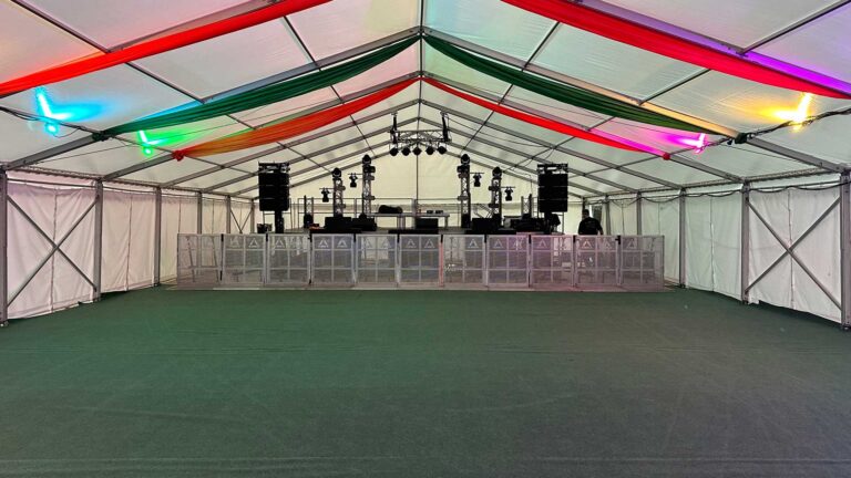 Marquee with stage at one end with speakers at the front and lights at the back