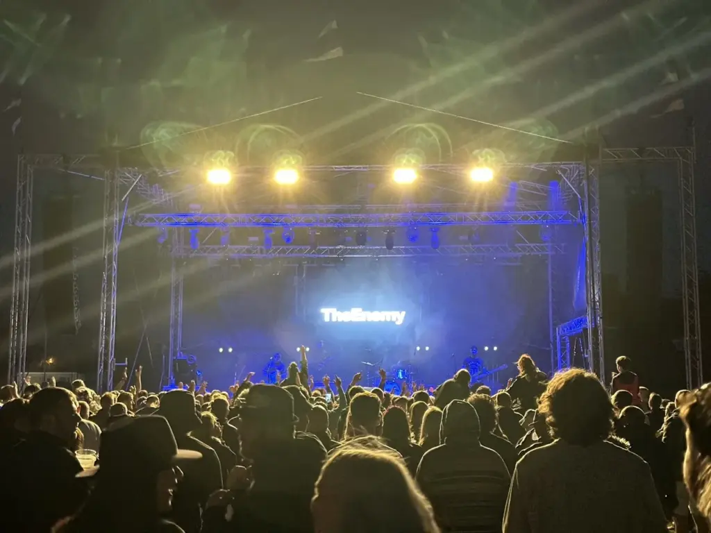 Crowd facing a lit festival stage at night with spotlights above at Heal Festival