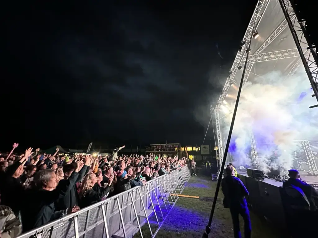 Haze and stage lighting rig above the crowd barrier at Heal Festival at night