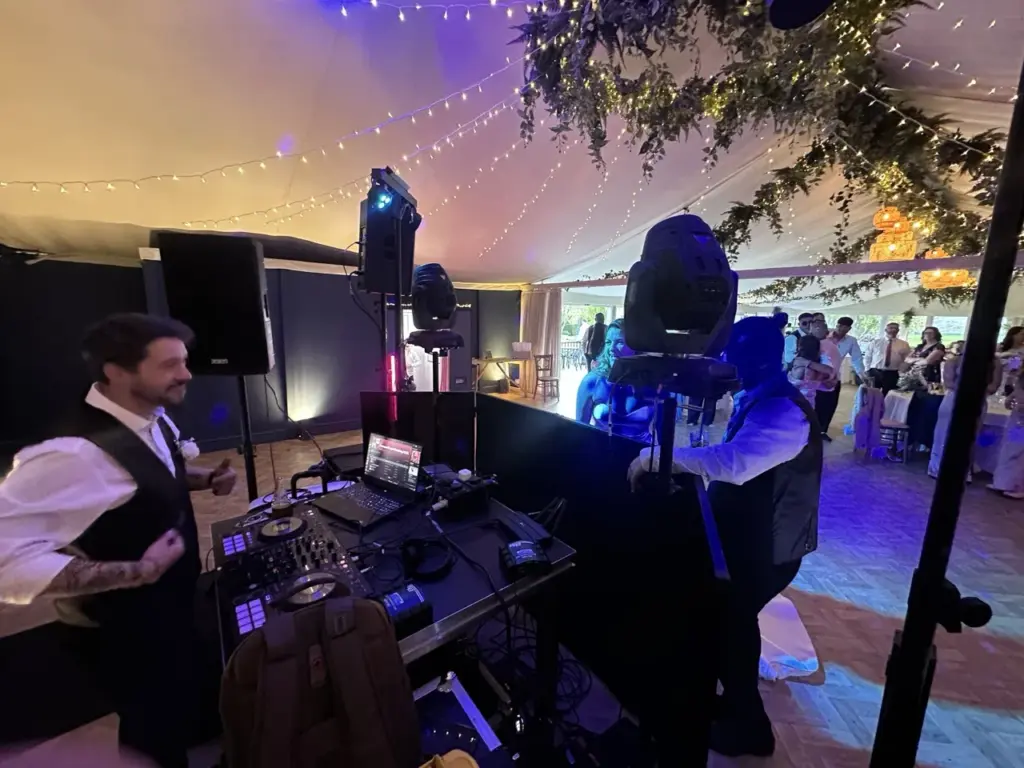 DJ and band equipment at a wedding reception with purple lighting and a photographer behind