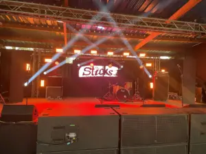 Stage with a video wall at the back, some lighting and some big speakers at the front