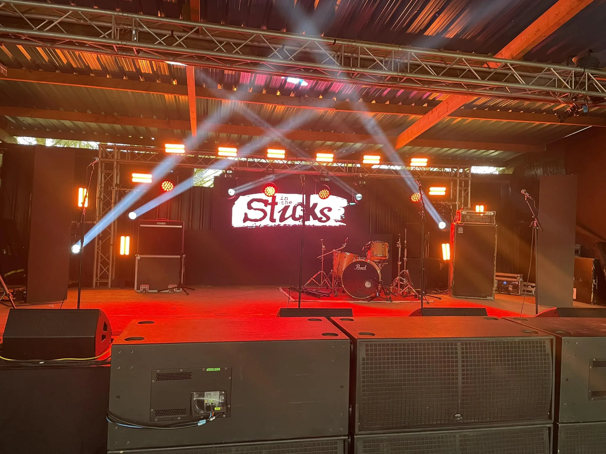 Stage with a video wall at the back, some lighting and some big speakers at the front