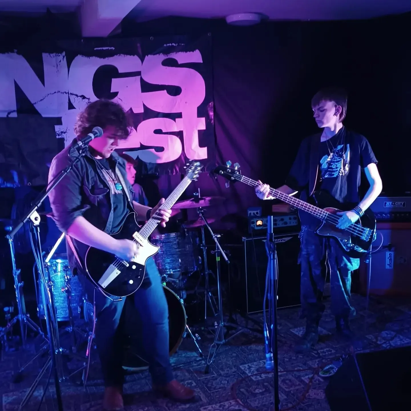 2 young men playing guitars