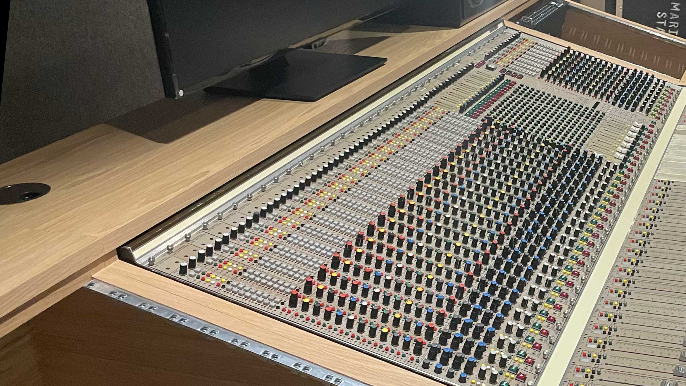 Mixing console mounted on custom studio desk