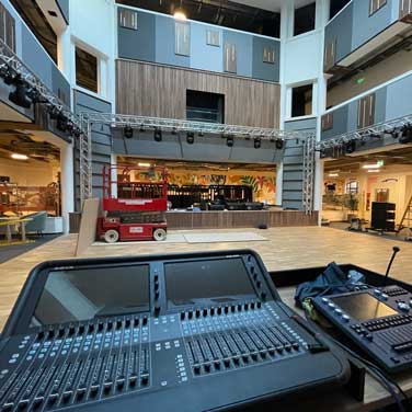 Front-of-house mixing console with a multi-level performance venue behind