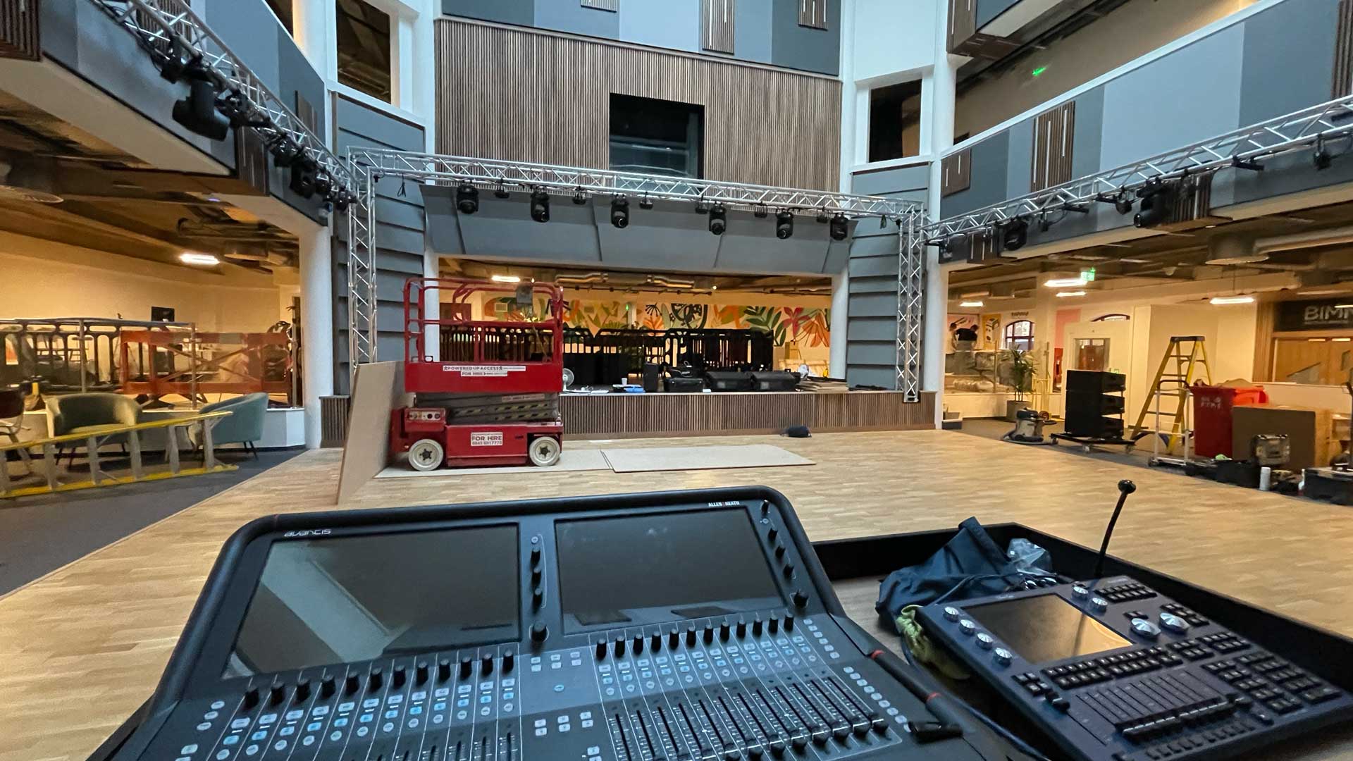 Front-of-house mixing console in a multi-level performance venue with wooden balconies