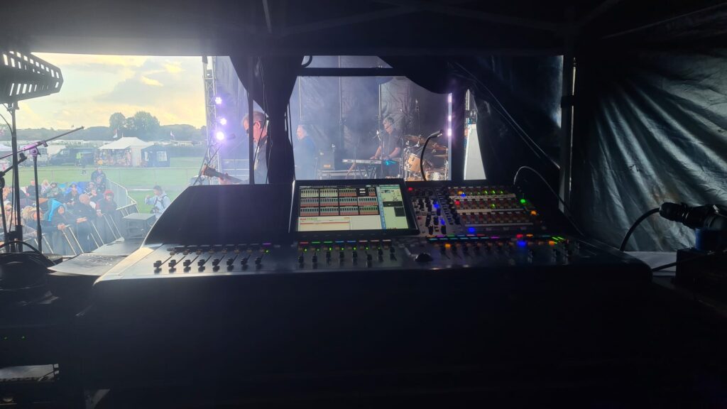 Looking from the side of stage out over a band playing.