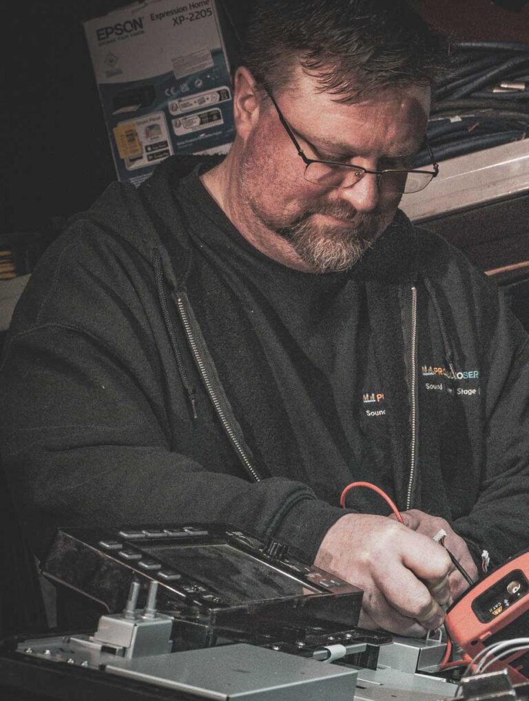 Ben Davies, bearded, working on equipment, in black and white