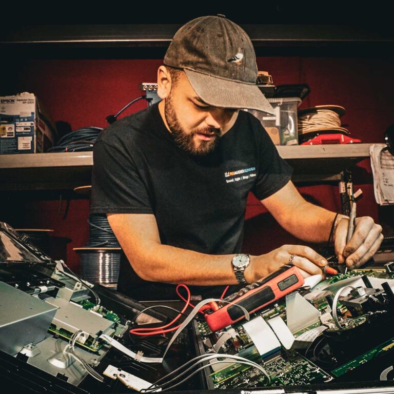 Jonah Mellor in a cap, working on equipment