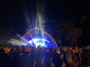 Audience watching a live performance ona stage with lights shinning out.