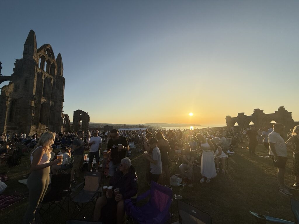 Sun setting behind the ruined arches of Whitby Abbey