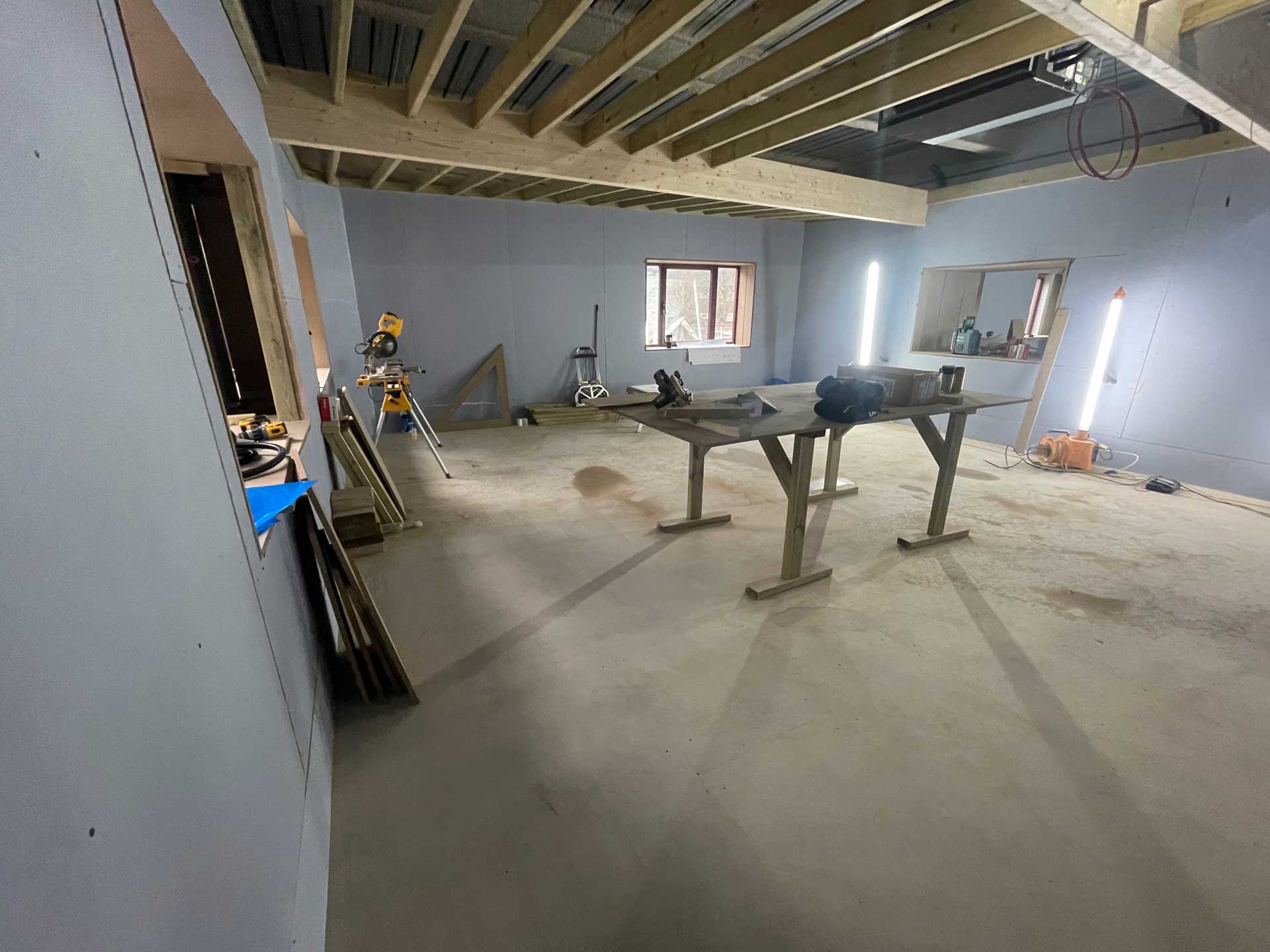 Empty studio shell with exposed ceiling beams, ready for fit-out