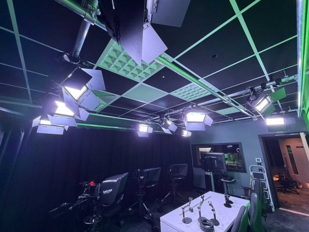 Virtual production studio with an overhead lighting grid and studio cameras