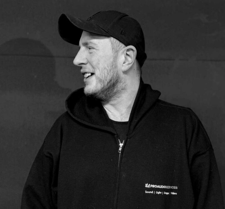 Ed Wainwright in a cap and black hoodie, in black and white