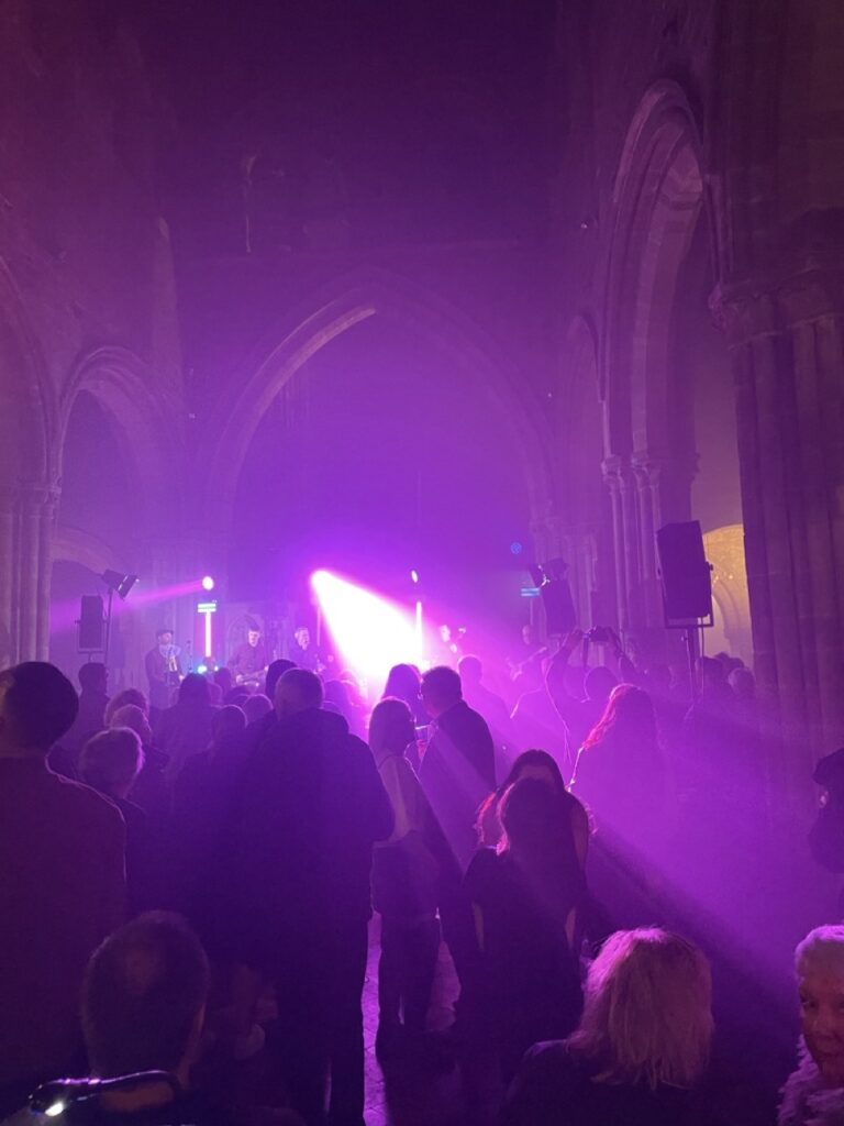 Purple stage lights beaming through haze inside a church