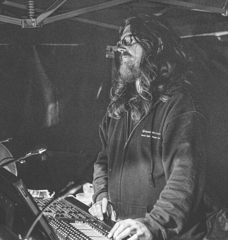 Joel Strawford working at a mixing desk, in black and white