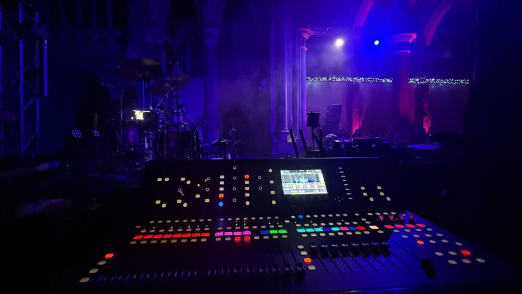 Illuminated mixing console in a dark venue under blue lighting
