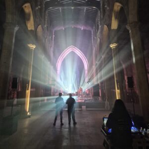 Light beams filling the nave of Sheffield Cathedral with two figures standing in the haze