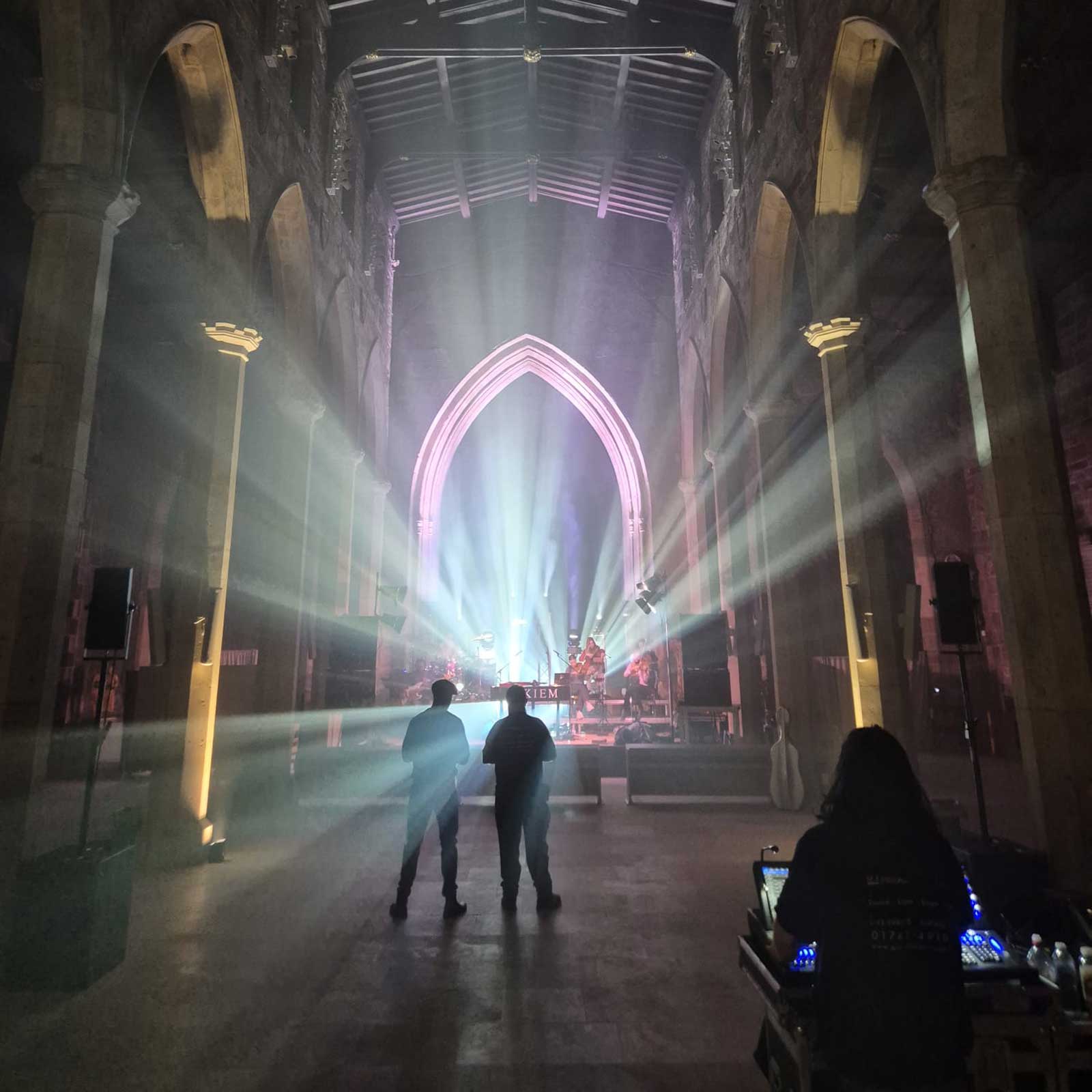 Light beams filling the nave of Sheffield Cathedral with two figures standing in the haze