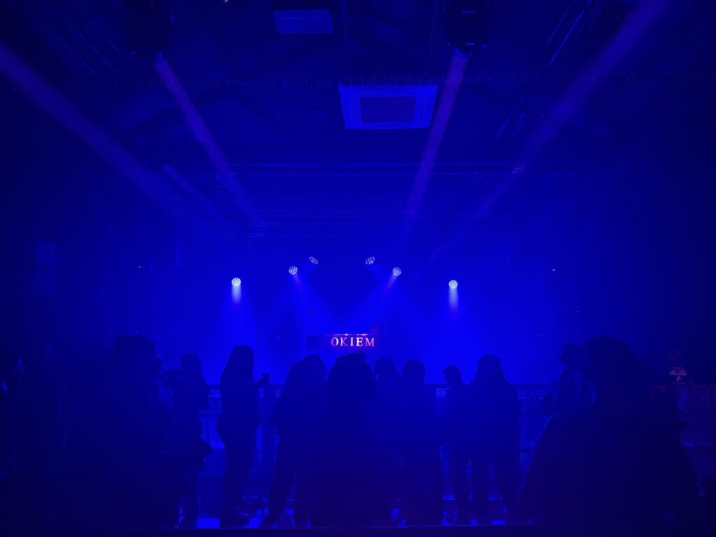 Dark room lit in blue with a stage at the far end