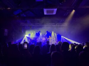 Audience watching a band perform in a stage.