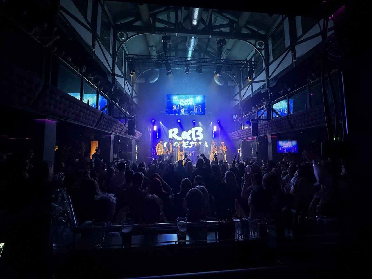 A band performing on a nightclub stage in Shrewsbury in front of a full audience
