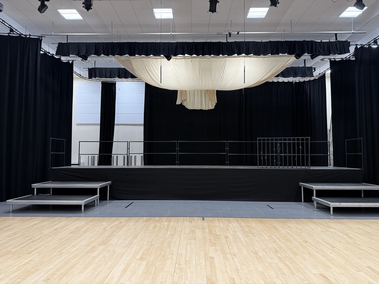 Stage st up in three tiers in a school hall.