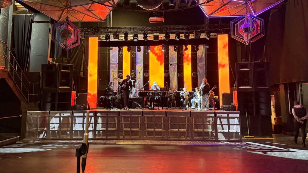 Venue stage with orange and red lighting and rows of lanterns hanging above