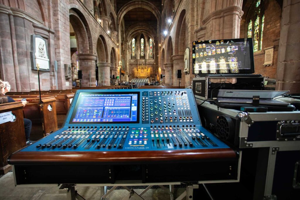 Digital mixing console set up in a church beside flight cases