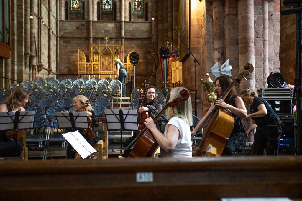 String players and singers performing at the front of a church