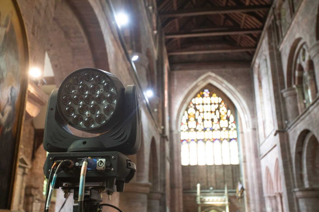 Moving-head light on a stand in the nave of a church