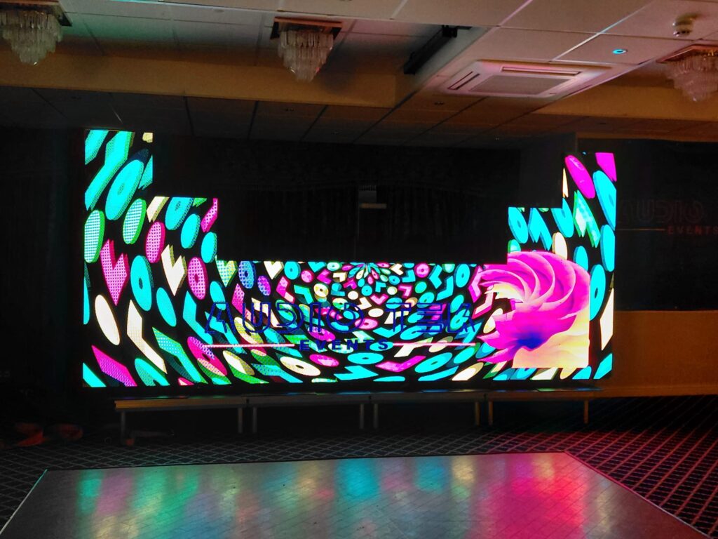 Curved LED video wall showing a colourful abstract pattern in a dark room