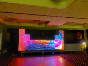 A video wall with bright patterns on set up in a hall.