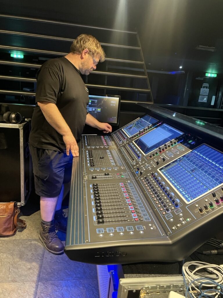 Engineer operating a large digital mixing console