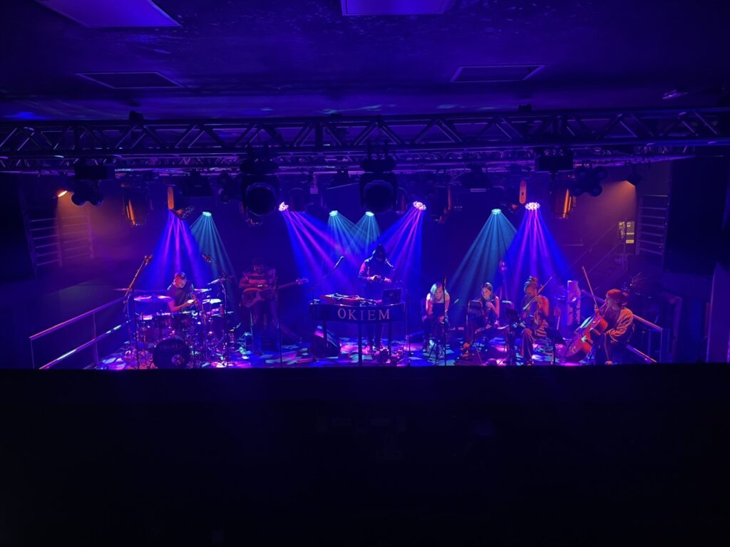 Orchestra on a stage lit in purple and blue