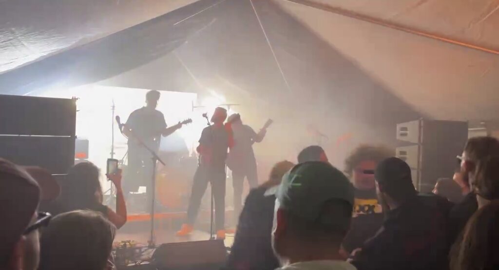 Band on stage in a hazy marquee with the crowd in the foreground