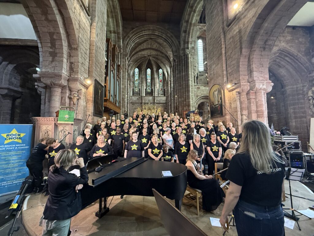 Choir performing in a church with the conductor in the foreground
