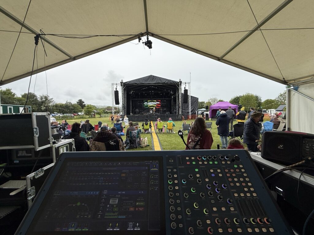 Mixing desk at front of house looking across the field to the covered stage
