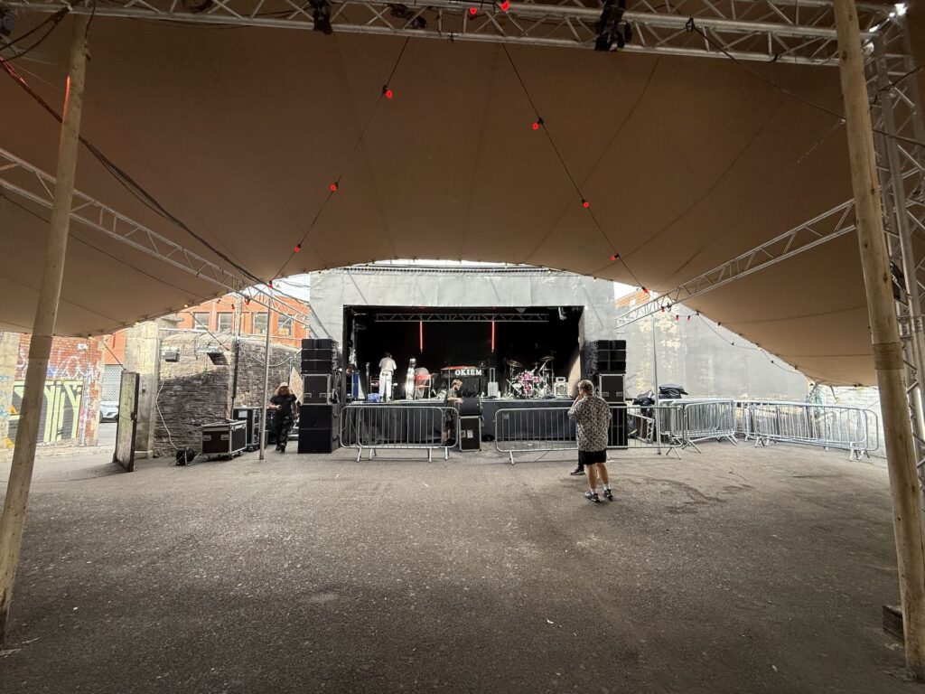 Empty marquee with a stage set up at the far end and equipment cases in front