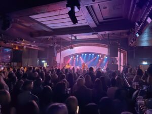 Audience watching R&B Orchestra on stage in Glasgow, with lights shining down on the band