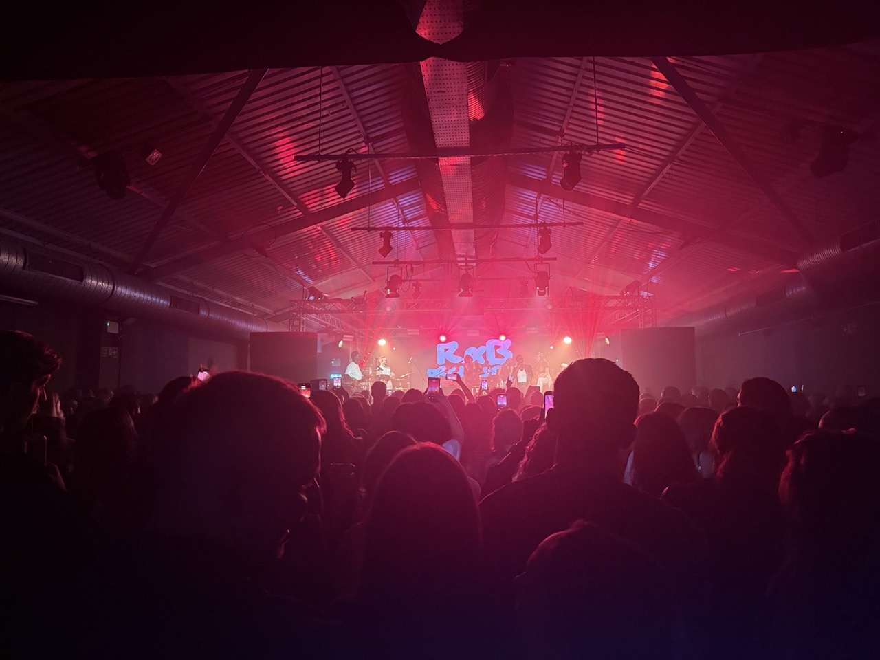 Audience watching R&B Orchestra on stage in Southampton, with lights shining behind the band