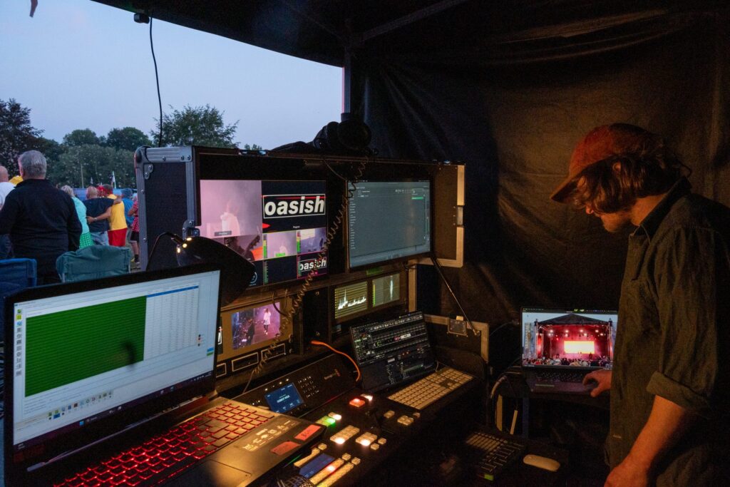 Technician working at a video and audio control desk with monitors