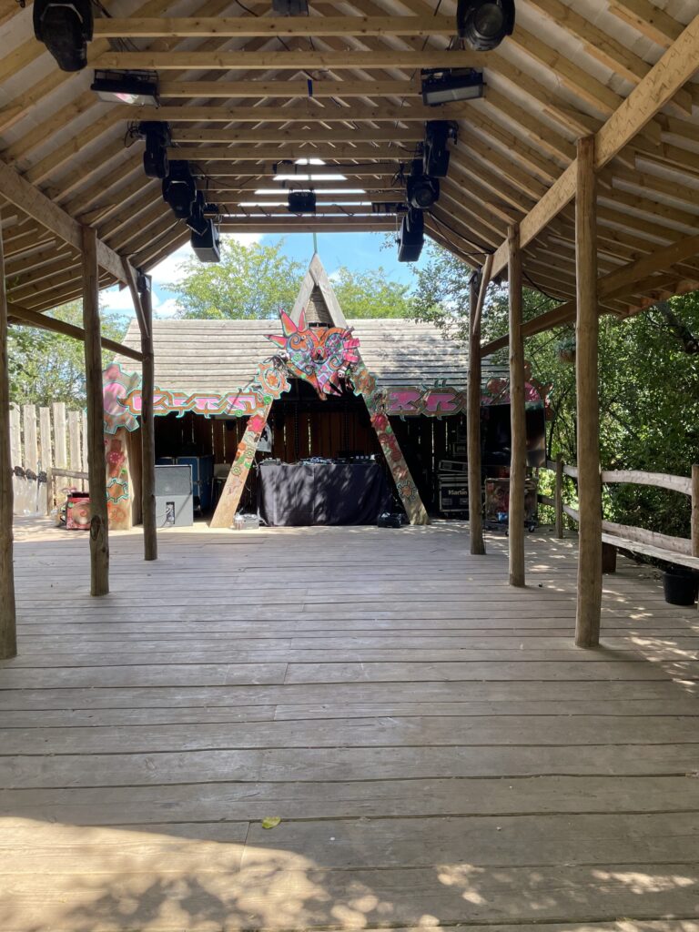 Wooden bandstand with a performer on stage at the back