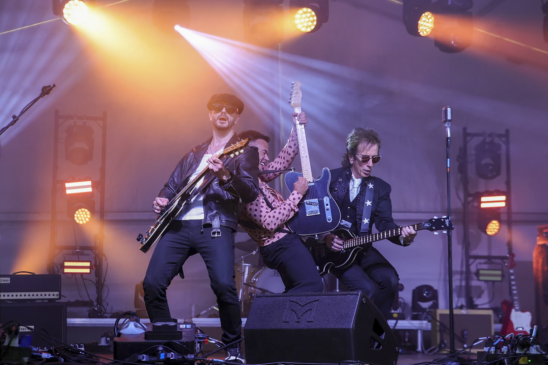 Two guitarists on stage at Oktoberfest 2026 under orange and blue lighting, supported by our full event production package