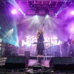 Band on stage at Avonstock 2026 lit in purple and magenta, with PA, lighting, video wall and live camera feeds by Pro Audio Services